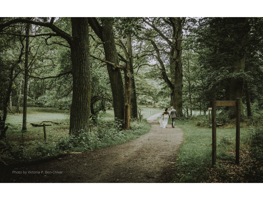 Wedding_Photoshoot_2021_at_ängsö_slott_walking_in_forest_bride_in_white_dress_groom_in_grey_suit